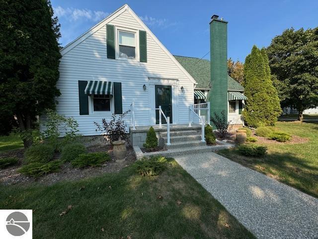 739 Stimson St, Cadillac, MI 49601 - bungalow-style house featuring a chimney and a front yard