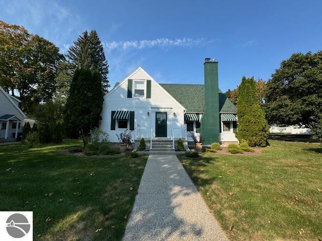 739 Stimson St, Cadillac, MI 49601 - view of front facade featuring a chimney and a front lawn