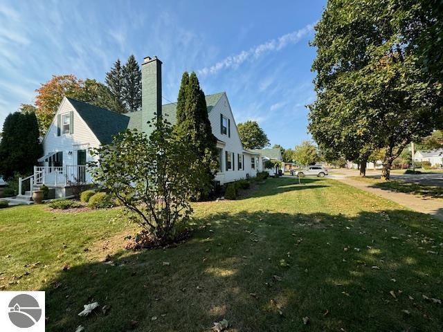 739 Stimson St, Cadillac, MI 49601 - view of property exterior with a lawn and a chimney