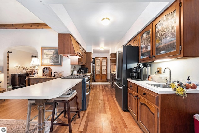 739 Stimson St, Cadillac, MI 49601 - kitchen featuring a sink, a peninsula, stainless steel appliances, a kitchen bar, and light countertops