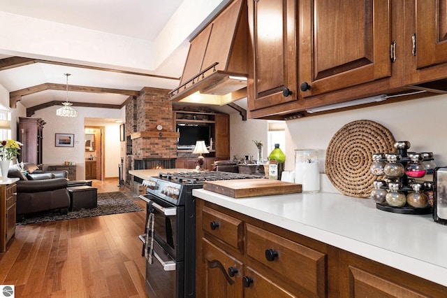 739 Stimson St, Cadillac, MI 49601 - kitchen with range with two ovens, open floor plan, wood-type flooring, light countertops, and lofted ceiling