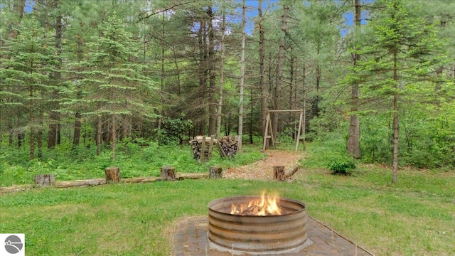 6369 Wooded Trl, Houghton Lake, MI 48629 - view of yard with an outdoor fire pit and a view of trees