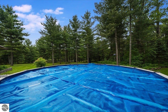 6369 Wooded Trl, Houghton Lake, MI 48629 - view of pool with a covered pool and a wooded view