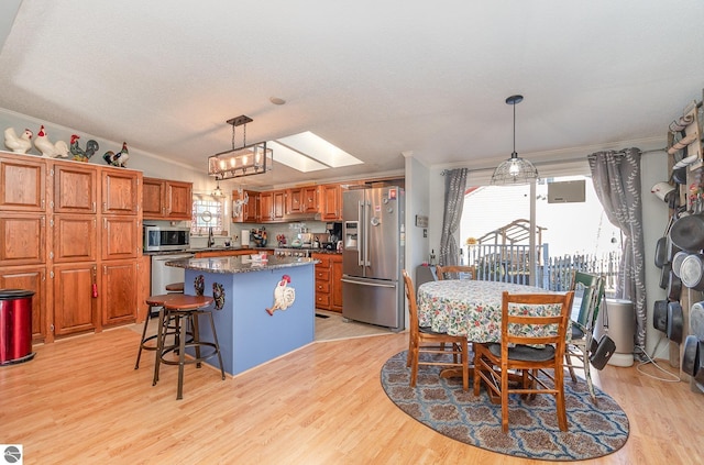 5489 W Lake Shore Dr, Weidman, MI 48893 - dining space featuring light wood-type flooring, ornamental molding, and a skylight