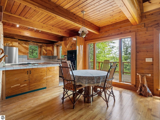 10037 Mud Lake Rd, Interlochen, MI 49643 - dining room with light wood-type flooring, plenty of natural light, a wood ceiling with exposed beams, and wooden walls
