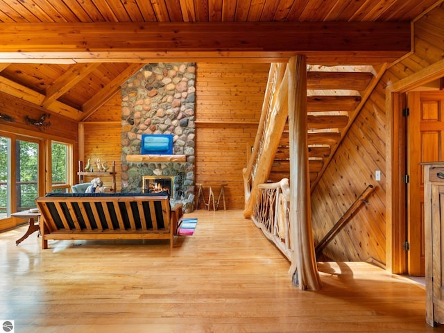 10037 Mud Lake Rd, Interlochen, MI 49643 - bedroom with wooden walls, light wood finished floors, wooden ceiling, and a fireplace