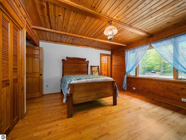 10037 Mud Lake Rd, Interlochen, MI 49643 - bedroom with a wooden ceiling with exposed beams, light wood-style flooring, and wood walls