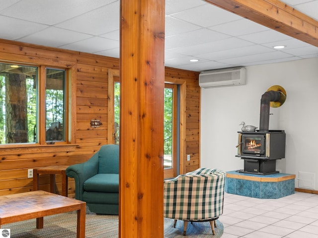 10037 Mud Lake Rd, Interlochen, MI 49643 - living area featuring a wall mounted AC, wood walls, a wood stove, light tile patterned floors, and recessed lighting