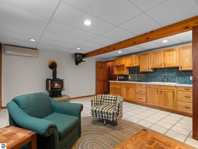 10037 Mud Lake Rd, Interlochen, MI 49643 - living area with a wall unit AC, a wood stove, light tile patterned floors, and recessed lighting