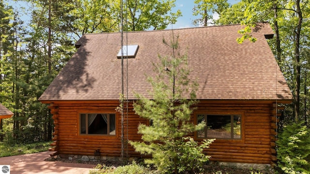 10037 Mud Lake Rd, Interlochen, MI 49643 - view of side of home featuring log exterior and roof with shingles