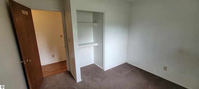 601 Monroe, Mancelona, MI 49659 - unfurnished bedroom with dark carpet and a closet