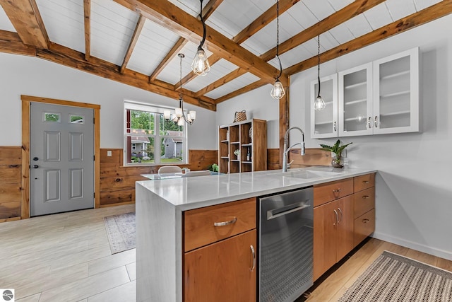 3872 Falling Leaf Trl, Traverse City, MI 49686 - kitchen featuring dishwasher, a peninsula, a wainscoted wall, light countertops, and wooden walls