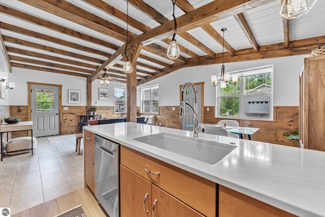 3872 Falling Leaf Trl, Traverse City, MI 49686 - kitchen with wainscoting, a chandelier, wooden walls, pendant lighting, and dishwasher