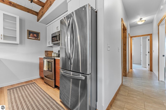 3872 Falling Leaf Trl, Traverse City, MI 49686 - kitchen featuring stainless steel appliances, white cabinetry, light countertops, light wood-style floors, and beamed ceiling