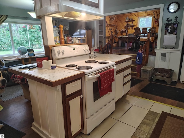 5094 SW Old Butler Rd Unit 1, South Boardman, MI 49680 - kitchen with white range with electric stovetop, tile counters, white cabinets, and light tile patterned floors