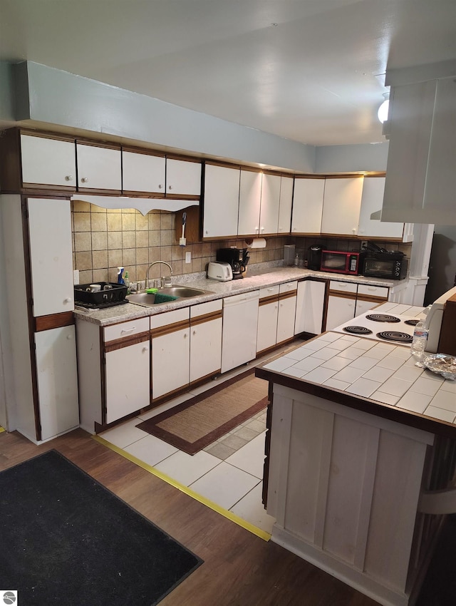 5094 SW Old Butler Rd Unit 1, South Boardman, MI 49680 - kitchen featuring white cabinetry, white dishwasher, and backsplash