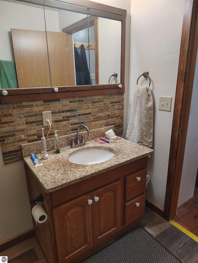 5094 SW Old Butler Rd Unit 1, South Boardman, MI 49680 - bathroom with wood finished floors, vanity, and backsplash