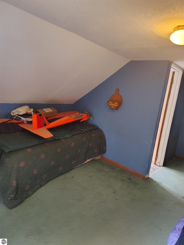 5094 SW Old Butler Rd Unit 1, South Boardman, MI 49680 - carpeted bedroom featuring vaulted ceiling and baseboards