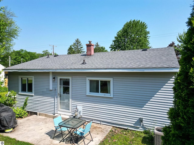 1220 E Gaylord St, Mount Pleasant, MI 48858 - rear view of house with a patio, a chimney, and roof with shingles