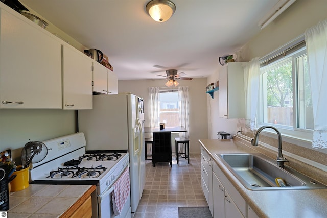 1220 E Gaylord St, Mount Pleasant, MI 48858 - kitchen with white appliances, plenty of natural light, white cabinetry, and light countertops