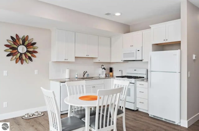 914-14 E Front St Unit 14, Traverse City, MI 49686 - kitchen with white appliances, dark wood finished floors, white cabinetry, and light stone counters
