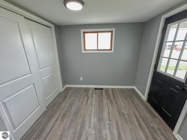 503 E Washington St, Coleman, MI 48618 - unfurnished bedroom with wood finished floors, a closet, and multiple windows