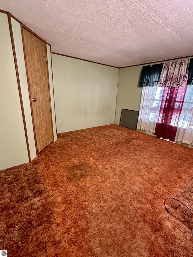 8334 Cinder Hill Rd, Mancelona, MI 49659 - empty room with carpet floors and a textured ceiling