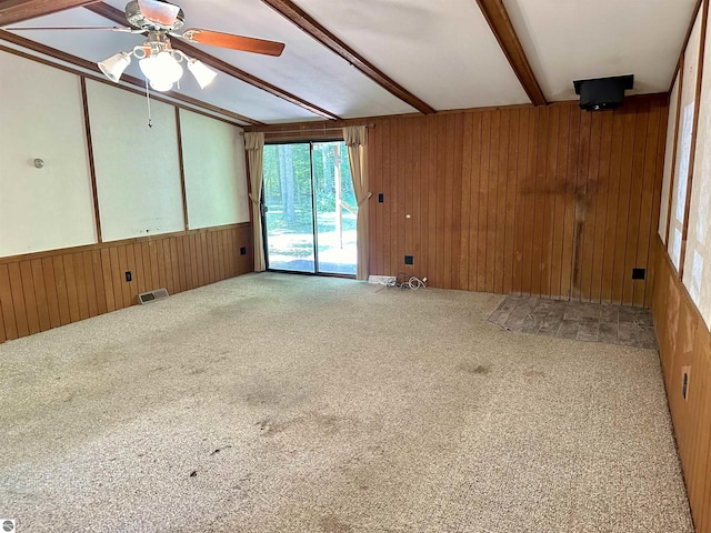 8334 Cinder Hill Rd, Mancelona, MI 49659 - unfurnished room featuring wooden walls, carpet, a ceiling fan, and beam ceiling