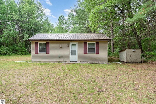 7373 Blue Ox Trl, South Branch, MI 48761 - view of front of property with a metal roof, a front yard, and a shed