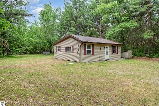7373 Blue Ox Trl, South Branch, MI 48761 - view of front facade with a front yard, a metal roof, and an outbuilding