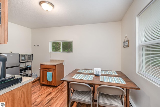 7373 Blue Ox Trl, South Branch, MI 48761 - kitchen with light wood-style floors, light countertops, stainless steel appliances, and brown cabinets