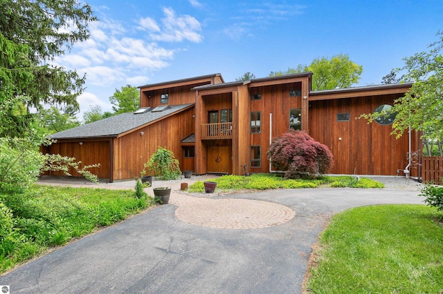 4340 E Huron River Dr, Ann Arbor, MI 48105 - view of front of house with a balcony, curved driveway, and roof with shingles