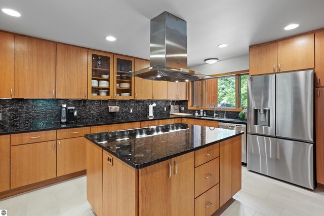 4340 E Huron River Dr, Ann Arbor, MI 48105 - kitchen featuring appliances with stainless steel finishes, island range hood, dark stone countertops, backsplash, and glass insert cabinets