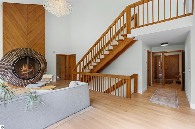 4340 E Huron River Dr, Ann Arbor, MI 48105 - living room featuring a towering ceiling, wood finished floors, a chandelier, and stairs