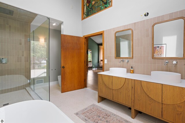 4340 E Huron River Dr, Ann Arbor, MI 48105 - full bath featuring double vanity, a freestanding bath, tiled shower, and a towering ceiling