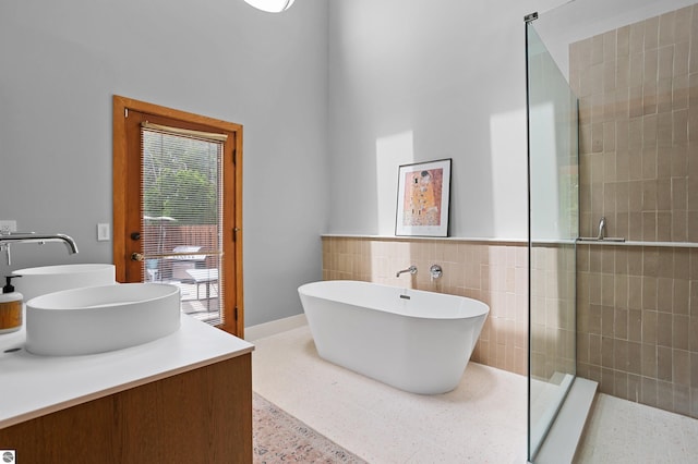 4340 E Huron River Dr, Ann Arbor, MI 48105 - bathroom with a tile shower, tile walls, a freestanding bath, double vanity, and speckled floor