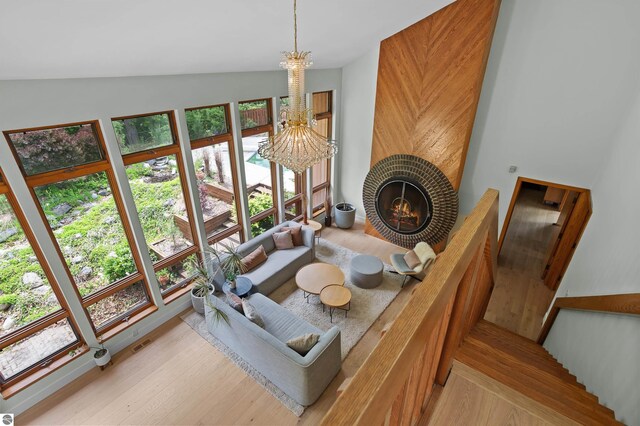 4340 E Huron River Dr, Ann Arbor, MI 48105 - interior space featuring a chandelier, vaulted ceiling, wood finished floors, and a tiled fireplace