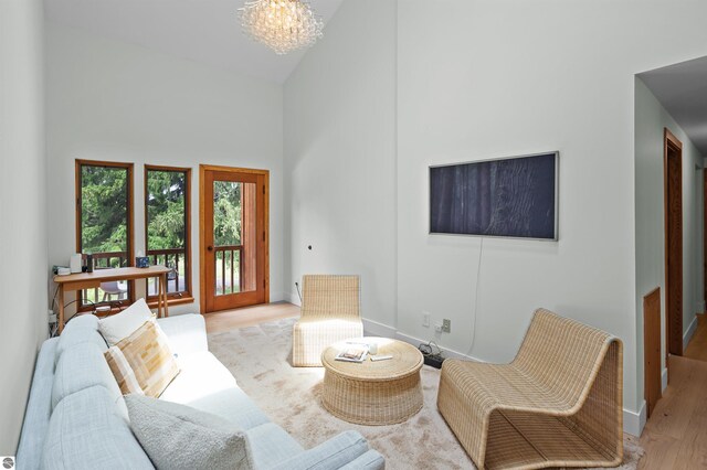 4340 E Huron River Dr, Ann Arbor, MI 48105 - living area featuring high vaulted ceiling, wood finished floors, and a chandelier