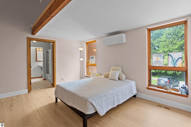 4340 E Huron River Dr, Ann Arbor, MI 48105 - bedroom featuring a wall mounted AC, light wood-type flooring, and ensuite bathroom
