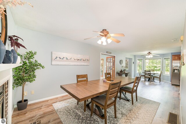 7746 Five Lakes Dr, Farwell, MI 48622 - dining space featuring a ceiling fan, light wood finished floors, and a fireplace