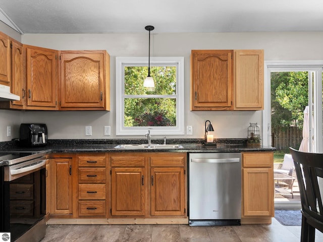 1708 Ketha Dr, Cadillac, MI 49601 - kitchen with appliances with stainless steel finishes, decorative light fixtures, dark stone countertops, under cabinet range hood, and brown cabinetry
