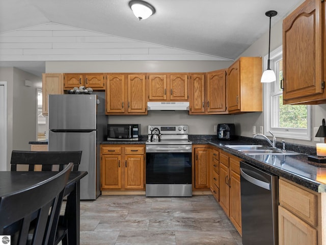 1708 Ketha Dr, Cadillac, MI 49601 - kitchen with appliances with stainless steel finishes, under cabinet range hood, lofted ceiling, brown cabinetry, and decorative light fixtures