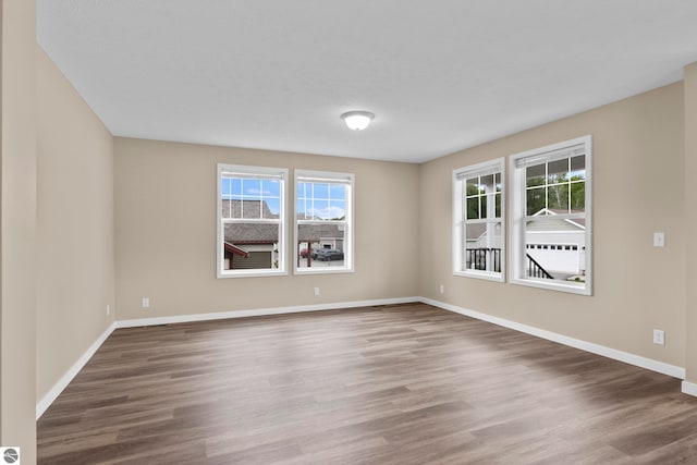 3874 Falling Leaf Trl, Traverse City, MI 49686 - unfurnished room featuring wood finished floors and baseboards