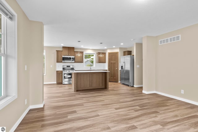 3874 Falling Leaf Trl, Traverse City, MI 49686 - kitchen featuring stainless steel appliances, light wood-style flooring, decorative backsplash, light countertops, and recessed lighting