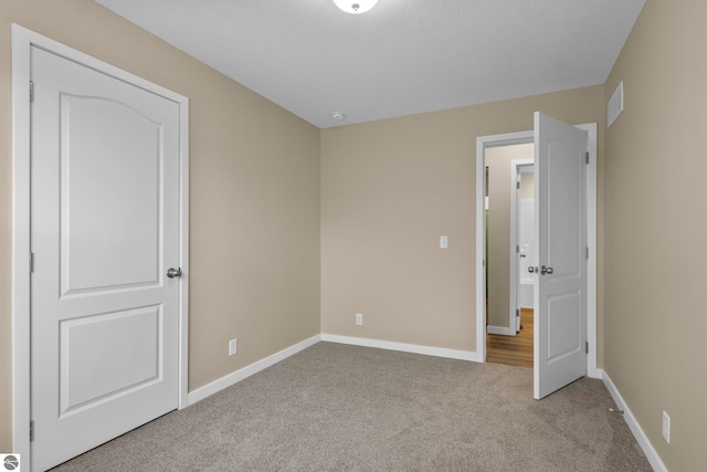 3874 Falling Leaf Trl, Traverse City, MI 49686 - unfurnished bedroom with carpet floors and baseboards