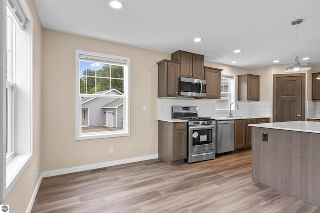 3874 Falling Leaf Trl, Traverse City, MI 49686 - kitchen featuring appliances with stainless steel finishes, light countertops, tasteful backsplash, light wood-style floors, and recessed lighting