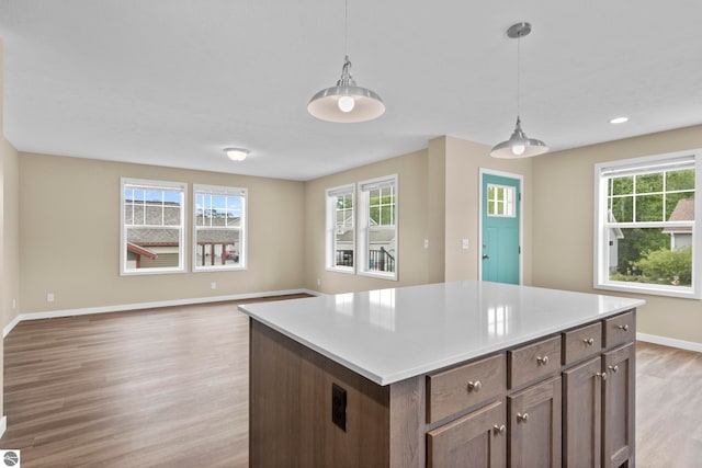 3874 Falling Leaf Trl, Traverse City, MI 49686 - kitchen with light wood-type flooring, healthy amount of natural light, hanging light fixtures, light countertops, and recessed lighting
