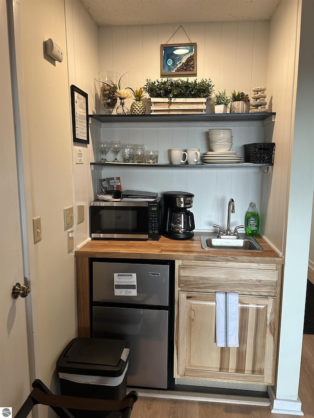 4673 N Crossover Dr, Bellaire, MI 49615 - indoor wet bar with stainless steel microwave, wood finished floors, and dishwashing machine