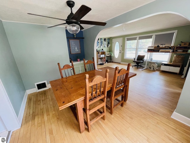 801 N Bridge St, Bellaire, MI 49615 - dining room with arched walkways, light wood-style floors, and a ceiling fan