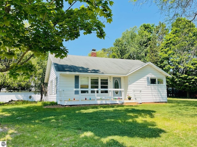 801 N Bridge St, Bellaire, MI 49615 - view of front facade featuring a front yard and a chimney